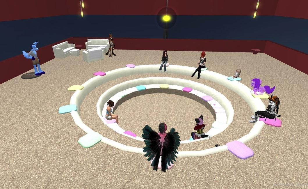 Avatars sit around a large outdoor circle in a colosseum