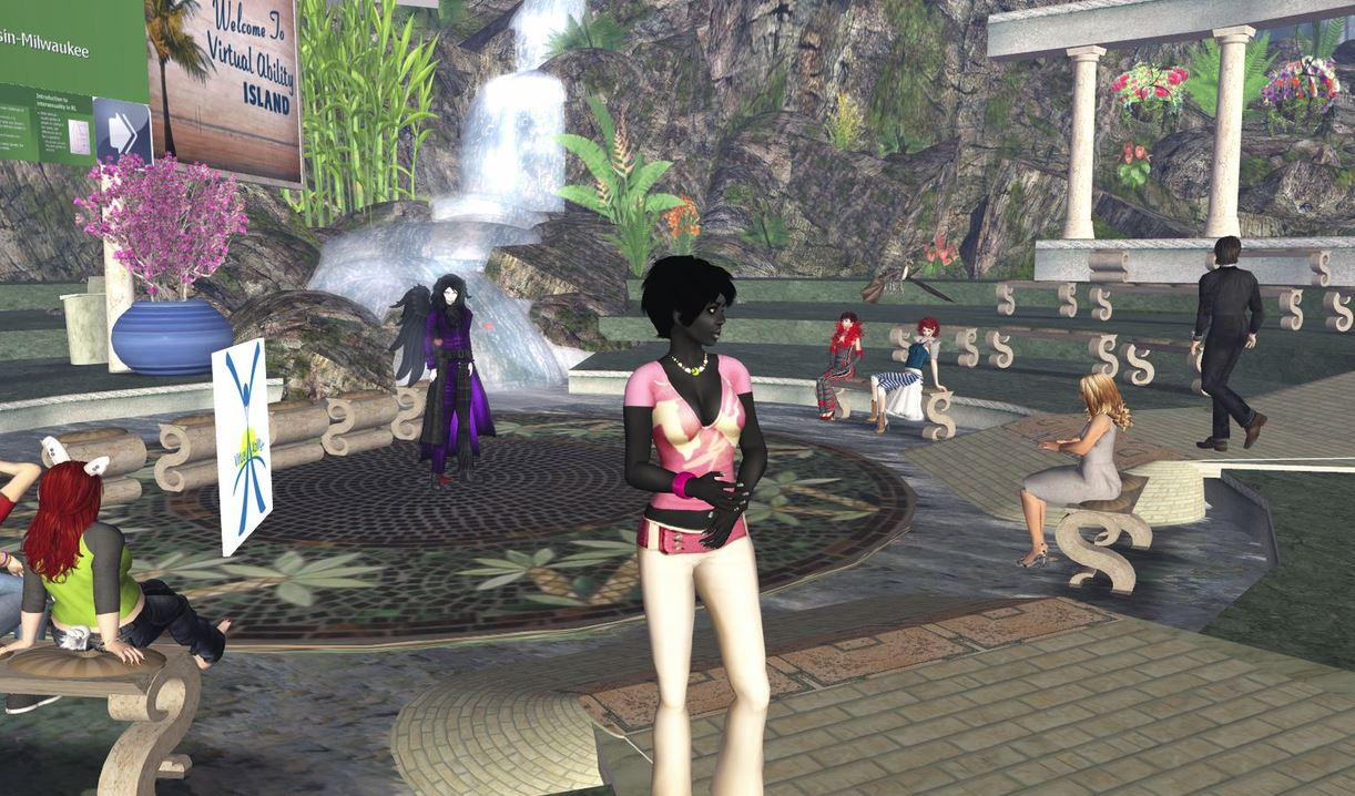 Virtual avatars stand in a Second Life screen next to a waterfall and the sign 'Virtual Ability Island'